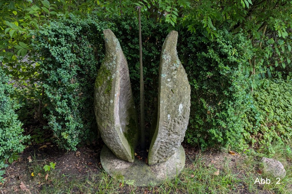 Steinskulptur mit Eisenstab in der Mitte